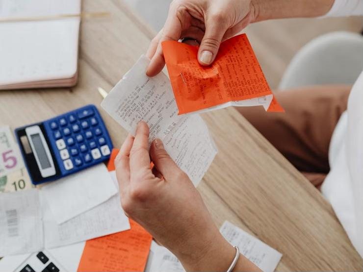 Illustrative photo: receipts and a calculator on a desk