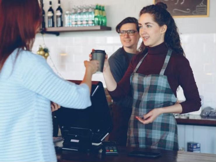 Illustrative photo: a barista serving a customer at the counter