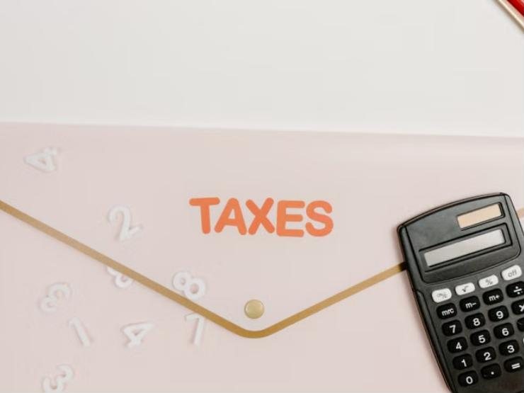 Illustrative photo: a folder marked taxes with a calculator